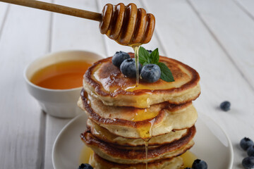 pancakes with fresh blueberry and honey on wooden rustic table