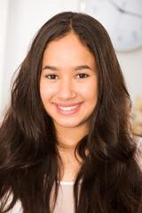 Portrait of young glad woman standing and smiling at home