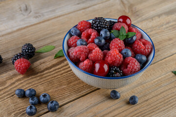 fresh berries on a wood plate  on rustic table