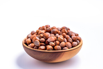 Hazelnuts in a wooden bowl on white background. Solid ripe Hazelnuts