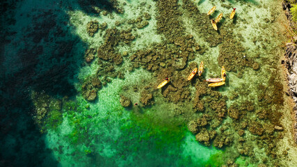 Tourists on the kayak in the lagoon with clear water, aerial view. Snorkeling and kayaking in the lagoon. Small lagoon with turquoise water. El nido, Philippines, Palawan. Summer and travel vacation