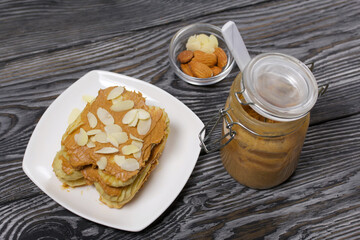 Eclairs cake smeared with cinnamon cream. Nearby ingredients for cooking. On black pine boards.