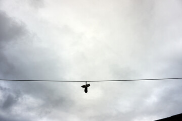 A cable with a pair of shoes hanging down from the wire