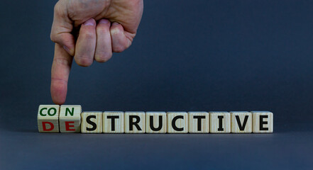 Destructive or constructive symbol. Male hand turns cubes and changes the word 'destructive' to 'constructive'. Business and constructive concept. Beautiful grey background, copy space. - obrazy, fototapety, plakaty