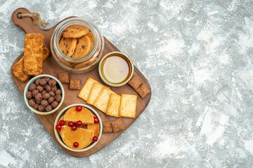 Delicious cakes honey and chocolate biscuits in a glass jar on blue background