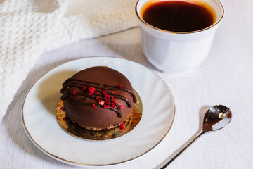 Contemporary chocolate mini mousse cakes with cream insert, covered with chocolate velvet spray and chocolate gourmet glaze, decorated with whipped chocolate ganache