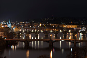 Fototapeta na wymiar .view of the Vltava river and the bridges on it between them and the Charles Bridge and light from street lighting and the roofs of buildings in the center of Prague at night