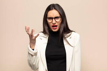 young hispanic woman looking angry, annoyed and frustrated screaming wtf or what’s wrong with you