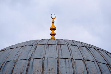 Vintage rustic dome of an old mosque with a golden crescent moon, islamic architecture