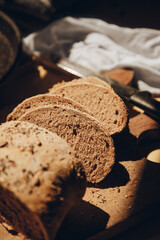 Integral flour homemade bread with seeds, cut into slices on wood plank