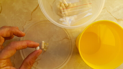 In the person's hand is a tablet, next to a glass of water. The patient will take medication. Vitamins for maintaining health during the coronavirus pandemic.