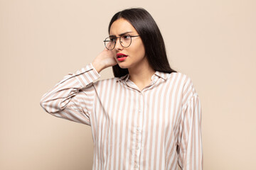 young hispanic woman looking serious and curious, listening, trying to hear a secret conversation...