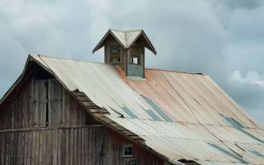 Fototapeta na wymiar Barn roof top under stormy skies
