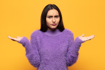 young hispanic woman looking puzzled, confused and stressed, wondering between different options,...