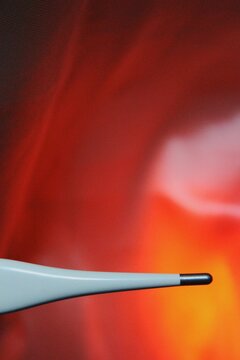 Thermometer tip resembling fever and hot temperature on pink red background 