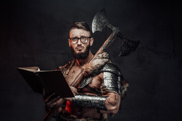 Sad nordic warrior in light armour with fur with eyeglasses and book holding huge axe on his...