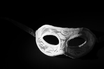 White festive carnival mask on a black background.