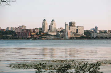 Naklejka premium The beautiful European Ukrainian city of Dnipro. Large and tall multi-storey buildings stand on the river and against the sky.