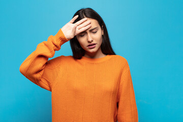 young hispanic woman looking stressed, tired and frustrated, drying sweat off forehead, feeling...