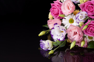 a bouquet of flowers from roses, lisianthus, daisies, chrysanthemums lies on a black mirror background with a reflection, free space for text.