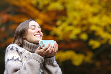 Happy woman breaths fresh air holding coffee cup