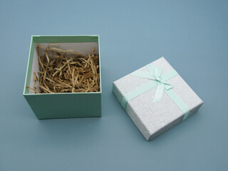 light green gift box with open lid on blue background