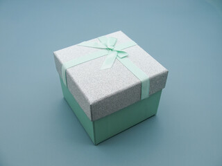 Light green gift box with closed lid on blue background