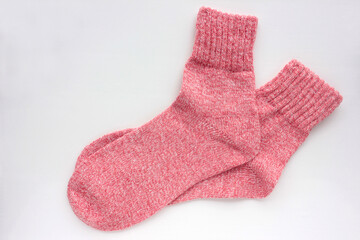 Pair of pink knitted socks on white background. Overhead view. Copy space
