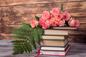 pink roses and books  on the wooden background