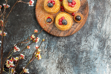 Half shot of classic American pancakes with flowers on gray background