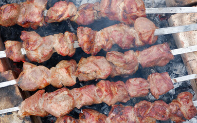 Delicious grilled pork meat in BBQ Barbecue with pork meat. Kebabs on the grill. Close-Up Of Meat On Barbecue Grill With Smoke.