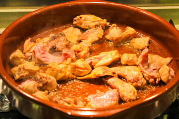 Rabbit and chicken meat frying in a clay pot