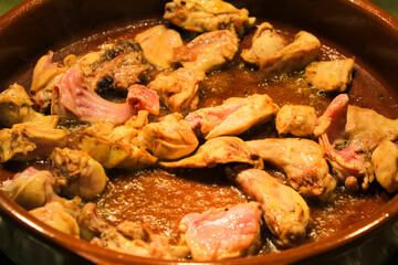 Rabbit and chicken meat frying in a clay pot