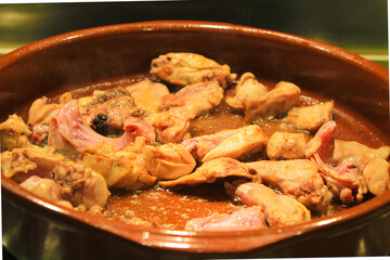 Rabbit and chicken meat frying in a clay pot