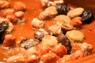 Traditional Spanish sausages frying in a clay pot