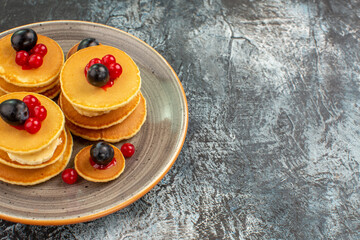 Fruits on classic American pancakes on gray background
