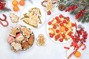 Christmas new year food, traditional festive salad olivier and cheese with tomatoes, grapes and gingerbread with fir branches and cones and decorations, dish design idea, selective focus,