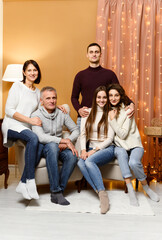 mom and dad are sitting in a chair. husband with wife and sister next to their parents. children and parents. new year holidays. Christmas. weekend with family