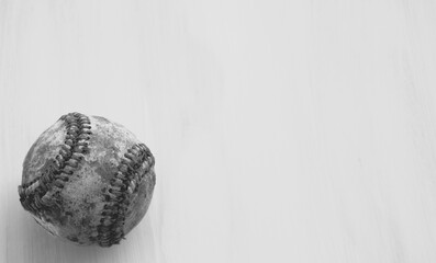 Old baseball ball laying on background for sport in black and white.