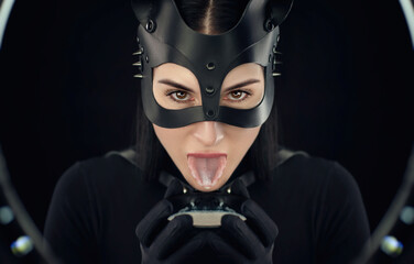 a woman in a black body belt and cat mask with a bowl of milk