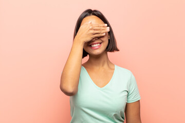 young hispanic woman covering eyes with one hand feeling scared or anxious, wondering or blindly...