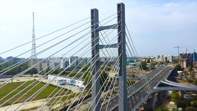 Ciurel passage, bridge over a river with moving cars, construction works, field and TV tower near it. Residential buildings on the background. View from the drone. Bucharest, Romania