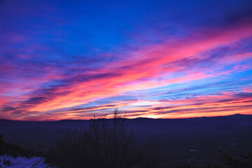 Spectacular winter sunset with clouds with red and pink colors crossing the sky after a long motorbike ride