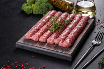 Fresh raw pork sausages with spices on a wooden cutting board