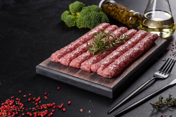 Fresh raw pork sausages with spices on a wooden cutting board