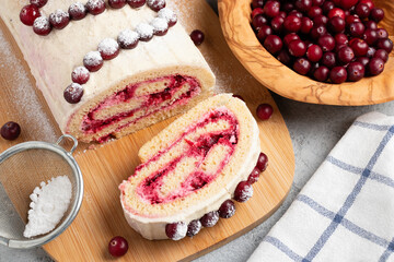 Homemade biscuit sweet roll with cranberries and cream on gray table, top view, flat lay