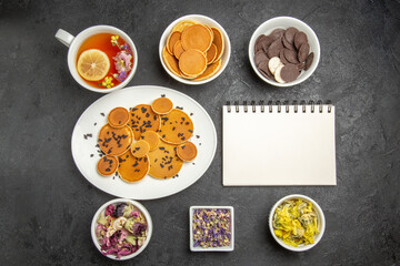 top view yummy pancakes with tea and cookies on the dark background sweet pie dessert cake