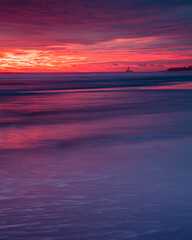 Fototapeta premium Colourful sunrise over Blyth Beach on the coast of Northunberland, England, UK. On a cold winter morning.