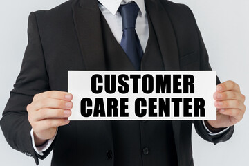 A businessman holds a sign in his hands which says - CUSTOMER CARE CENTER