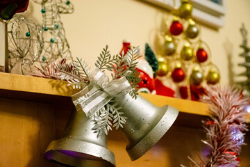 Christmas decoration with fireplace in room with silver bells and garlands.